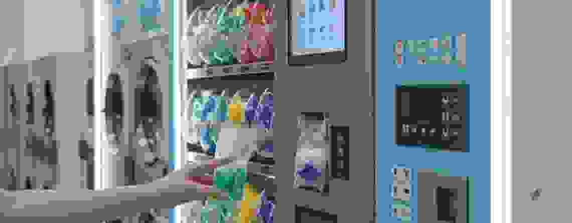 Person retrieving detergent from a modern laundry vending machine